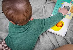 Ein sieben Monate altes Baby spielt auf einer Decke - Jessica Kliem/dpa-tmn