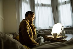 Frau sitzt vor einer Tageslichtlampe - Christin Klose/dpa-tmn