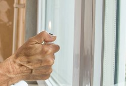 Eine Frau h&auml;lt ein Feuerzeug an ein Fenster - Christin Klose/dpa-tmn