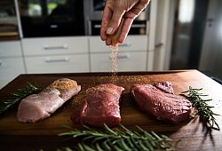 Eine Perosn würzt Fleisch - Andreas Arnold/dpa/dpa-tmn