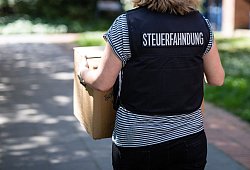Mitarbeiterin der Steuerfahndung trägt beschlagnahmte Unterlagen - Christoph Schmidt/dpa-tmn