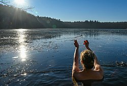 Frau geht in einem Loch im Eis baden - Patrick Pleul/dpa/dpa-tmn