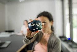Eine Frau nutzt im Büro einen Anti-Aggressionsball - Klaus-Dietmar Gabbert/dpa-tmn