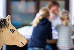 Ein Elternteil sitzt mit seinen Kindern an einem Tisch - Guido Kirchner/dpa/dpa-tmn