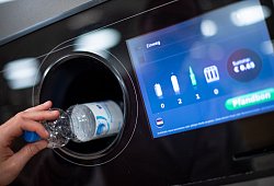 Ein Mann steckt eine Pfandflasche in einen Leergutautomaten - Monika Skolimowska/dpa/dpa-tmn