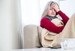 Eine Frau sitzt krank auf einem Sofa - Christin Klose/dpa-tmn