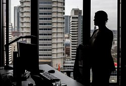 Frau steht an ihrem Arbeitsplatz am Fenster - Hannes P Albert/dpa/dpa-tmn