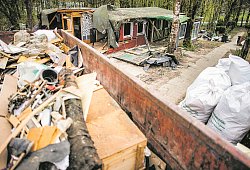 Eine Mulde mit entsorgten Teilen steht vor der bereits zum Teil abgerissenen Parzelle des mutmaßlichen Täters auf dem Campingplatz Eichwald im Ortsteil Elbrinxen. - dpa