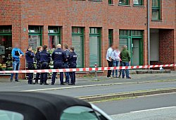 Polizisten und Passanten vor dem Haus am Tag der Tat. - dpa