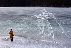 Eine Frau steht am zugefrorenem See nahe einer Einbruchstelle - Karl-Josef Hildenbrand/dpa/dpa-tmn