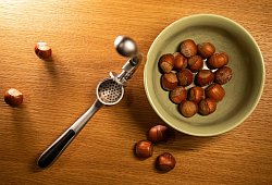 Haselnüsse liegen neben einer Knoblauchpresse - Christin Klose/dpa-tmn