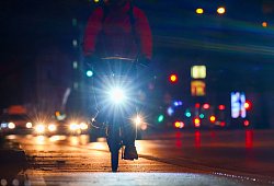 Radfahrer fährt mit Licht am Morgen eine Straße entlang - Christian Charisius/dpa/dpa-tmn