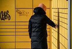 Eine Frau holt ein Paket bei einer Packstation ab - Zacharie Scheurer/dpa-tmn