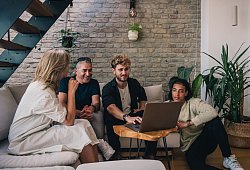 Eine Gruppe sitzt gemeinsam vor einem Laptop - Zacharie Scheurer/dpa-tmn