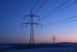 Strommasten in der Morgendämmerung auf einem Feld - Uwe Zucchi/dpa/dpa-tmn