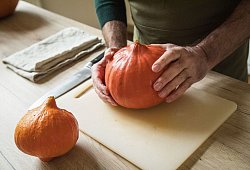Ein Mann hält einen Hokkaido-Kürbis in den Händen - Christin Klose/dpa-tmn