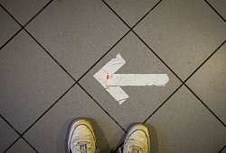 Ein Pfeil aus Klebeband ist auf einem Fußboden zu sehen - Sebastian Willnow/dpa/dpa-tmn