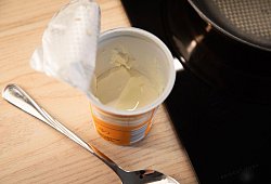 Ge&ouml;ffneter Becher Schmand steht in einer K&uuml;che - Christin Klose/dpa-tmn