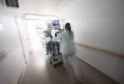 Pflegerin f&auml;hrt eine Intensivpatientin durch denGang einer Klinik - Marijan Murat/dpa/dpa-tmn