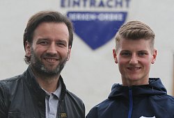 Strahlende Gesichter vor dem Vereinshaus und -wappen - Sebastian Lucas
