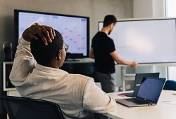 Eine Faru fasst sich an den Kopf in einem Meetingraum - Zacharie Scheurer/dpa-tmn