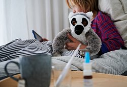 Krankes Kind liegt mit einem Kuscheltier im Bett - Annette Riedl/dpa/dpa-tmn