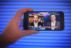Hand hält ein Mobiltelefon auf dem Das Gespräch von Alice Weidel mit Elon Musk auf der Plattform X zu sehen ist. *** Hand holds a mobile phone on which Alice Weidel's conversation with Elon Musk on Platform X can be seen. - IMAGO/Guido Schiefer
