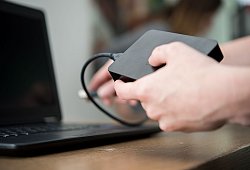 Eine Frau schliesst eine externe Festplatte an einem PC an - Henrik Josef Boerger/dpa/dpa-tmn