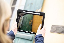 Eine Frau dokumentiert mit ihrem Tablet Sch&auml;den an einem Haus - Alexander Prautzsch/dpa-tmn