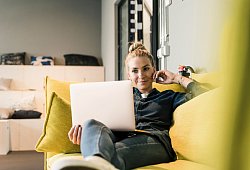 Frau sitzt mit Laptop auf einer Couch - Uwe Umstätter/Westend61/dpa-tmn
