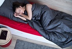 Frau schl&auml;ft in einem Bett - Christin Klose/dpa-tmn