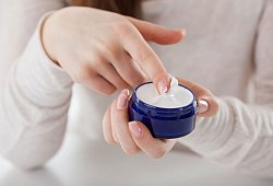 Eine Frau streicht mit dem Finger durch eine Cremedose - Christin Klose/dpa-tmn