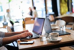 Ein Mensch arbeitet an seinem Computer in einem Café - Christian Charisius/dpa/dpa-tmn