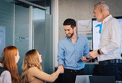 Ein Mann gibt einer Frau im B&uuml;ro die Hand - Zacharie Scheurer/dpa-tmn