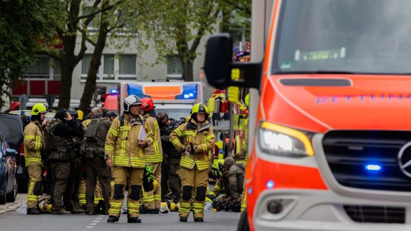 Polizeibeamte und Feuerwehrleute stehen vor einem Hochhaus in Ratingen. - © Rolf Vennenbernd/dpa