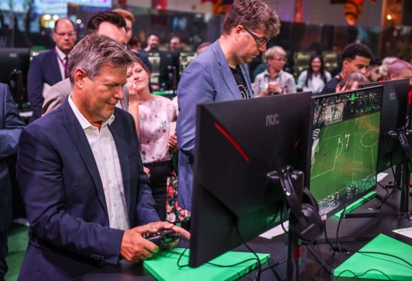 Der Bundeswirtschaftsminister Robert Habeck und sein Staatssekretär Michael Kellner (beide Grüne) spielen bei der Gamescom ein Fußballspiel zur Probe. - © Oliver Berg/dpa