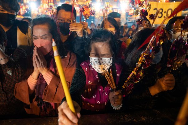 Gläubige mit Mund-Nasen-Schutz verbrennen ihre ersten Räucherstäbchen, während sie im Wong-Tai-Sin-Tempel in Hongkong das Neujahrsfest feiern. - © Bertha Wang/AP/dpa