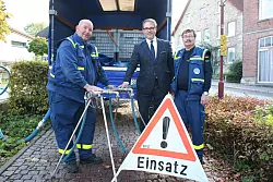 Ingo Hartmann (links) und Wolfgang Anton (rechts) vom Technischen Hilfswerk sowie Christian Brachvogel vom Wasserbeschaffungsverband Hohenhausen stehen an der Leitung vor dem Altenheim, an der die Hohenhauser Trinkwasser zapfen k&ouml;nnen.&nbsp; - &copy; Kirsten Fuhrmann