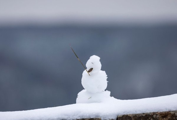 Ein kleiner Schneemann steht im Dezember 2023 auf einer Mauer. (Archivbild) - © Thomas Banneyer/dpa