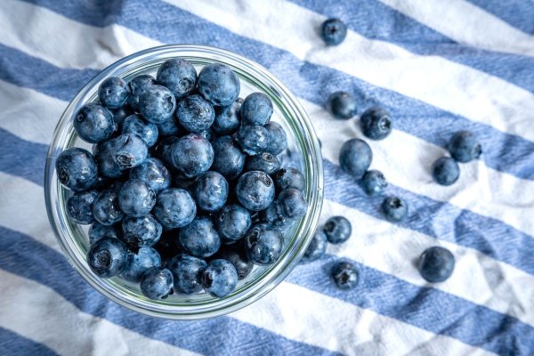 Beeren statt Chips oder Nüsschen: Heidelbeeren, auch Blaubeeren genannt, liegen auf einem Esstisch und werden gern gesnackt. - © Sina Schuldt/dpa