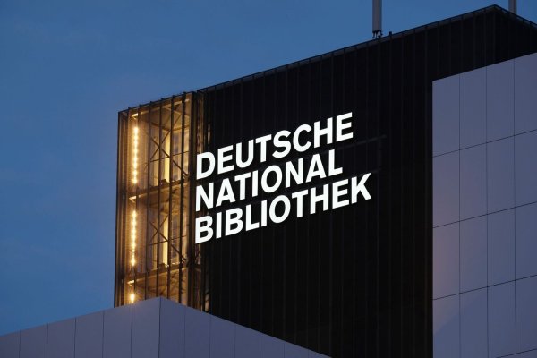 Der Schriftzug "Deutsche Nationalbibliothek" (DNB) leuchtet an einem 55 Meter hohen Gebäude der früheren Deutschen Bücherei. (Archivbild) - © Sebastian Willnow/dpa