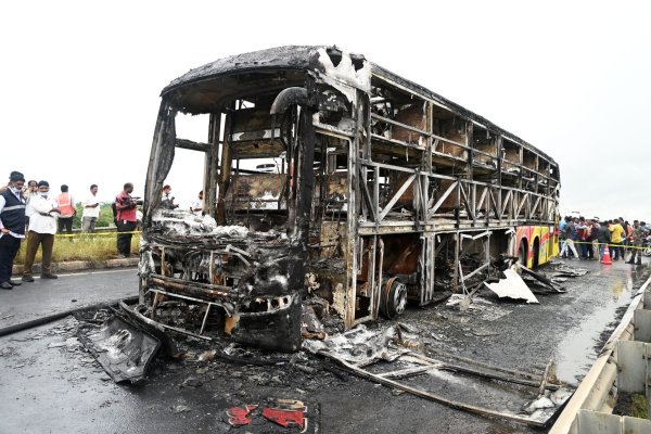 Die verkohlten Überreste des Passagierbusses liegen auf einer Landstraße im Dorf Chinnatekuru. - © -/AP/dpa