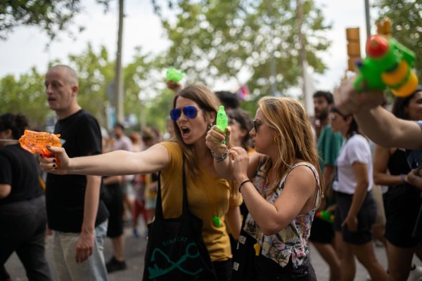 Demonstrantinnen verpassen Urlaubern eine unerbetene Abkühlung aus Wasserpistolen. - © Lorena Sopêna/EUROPA PRESS/dpa