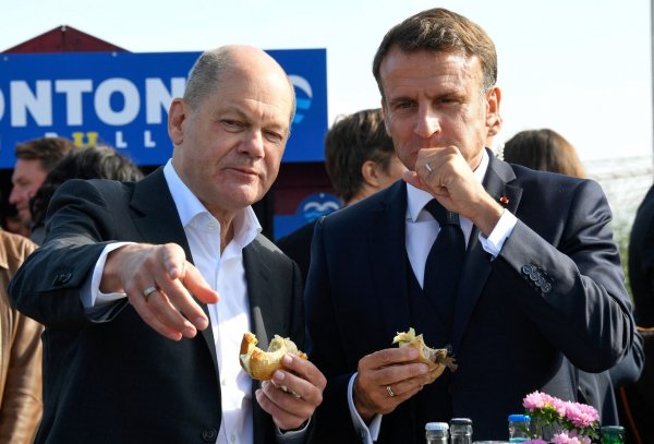 Bundeskanzler Olaf Scholz (SPD) und Frankreichs Präsident Emmanuel Macron (r) essen an der Elbe in Hamburg-Blankenese Fischbrötchen. - © Fabian Bimmer/Reuters/Pool/dpa