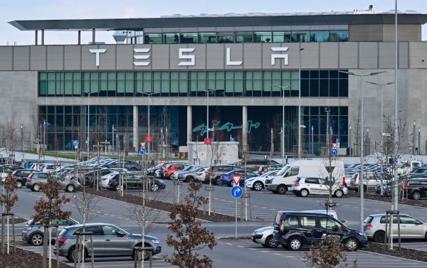 Nur wenige Autos von Mitarbeitern der Tesla-Gigafactory Berlin-Brandenburg stehen vor dem Werk. - © Patrick Pleul/dpa