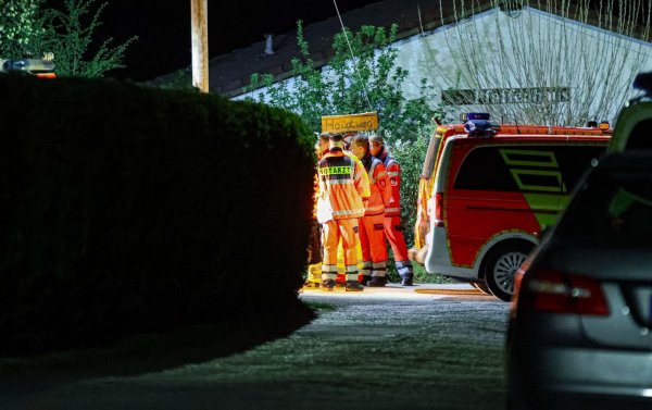 Helfer und ein Notarzt stehen in einer Kleingartenanlage in Wuppertal. Sie können nicht mehr helfen. - © Florian Schmidt/dpa