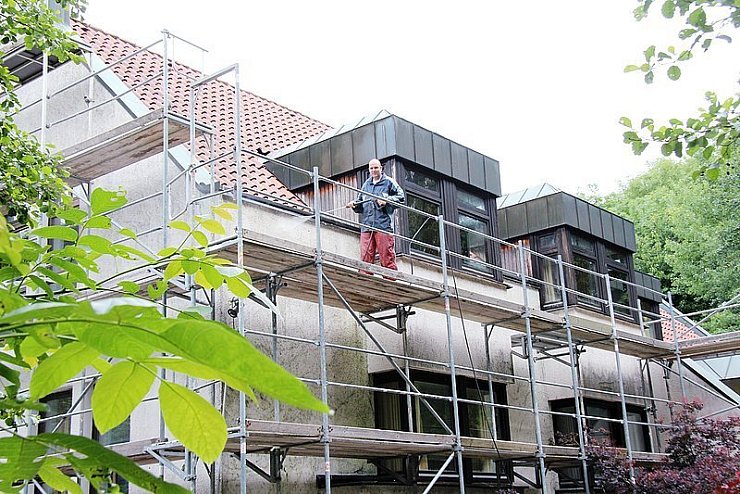 Matthias Bloch aus Augustdorf rückt dem Schmutz an der Fassade mit einem Hochdruckreiniger zu Leibe. - © Foto: Becker