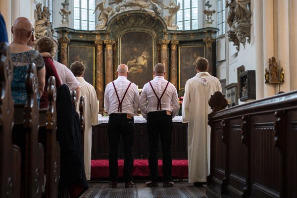 Zwei homosexuelle Männer stehen bei ihrer Trauung in der Berliner Marienkirche mit zwei Pfarrern vor dem Altar. Für immer mehr homosexuelle Paare erfüllt sich der Wunsch nach einer kirchlichen Trauung. Auch die Lippische Landeskirche schafft nun diese Möglichkeit. - © Wolfram Kastl/dpa