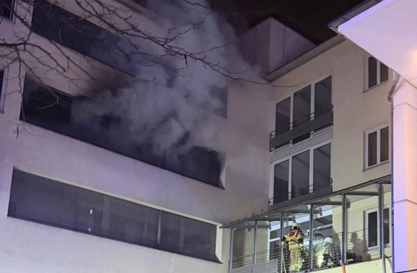 Feuerwehrleute mit Atemschutz arbeiten in dem brennenden Mehrfamilienhaus. - © -/Feuerwehr Recklinghausen/dpa
