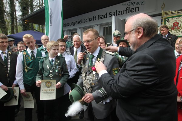 Neuer König: Matthias Drewes nimmt von Schützenkreis Lippe-Chef Dr. Stephan Breuning (verdeckt) und Peter Iwanowicz (rechts) vom Landesverband Lippe die Insignien entgegen. - © Daniel Hobein